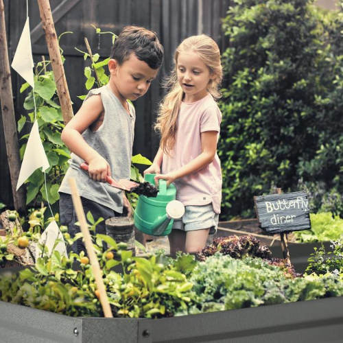 Děti pěstující zeleninu ve vyvýšeném záhonu